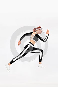 Strong athletic woman sprinter, running on white background wearing sportswears. Fitness and sport motivation. Runner