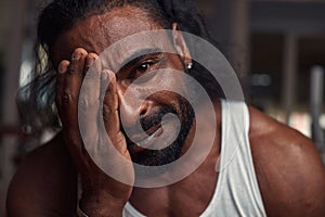 a strong black man with a beard looks into the camera and smiles