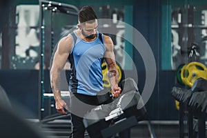 Strong bodybuilder choosing weight of dumbbell for training
