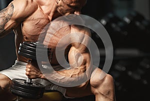 Strong bodybuilder doing exercise with dumbbell