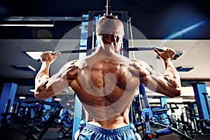 Strong Bodybuilder Doing Heavy Weight Exercise For Back On Machine