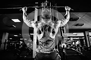 Strong Bodybuilder Doing Heavy Weight Exercise For Back On Machine