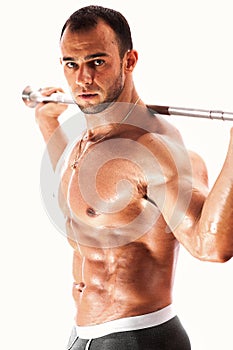 Strong bodybuilder posing shirtless with barbell