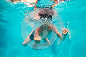 Strong boy posing swim underwater in scuba mask