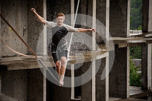 Strong and brave young man balancing on a slackline