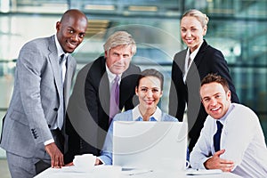 Strong business team. Group of multi ethnic business people smiling with laptop on table.