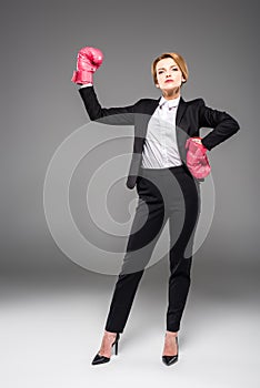 strong businesswoman posing in formal wear and boxing gloves