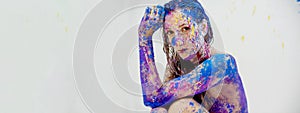 Strong colored portrait, head resting on arm, with blue purple magenta bodypainting, facepainting, sexy brunette woman, painted