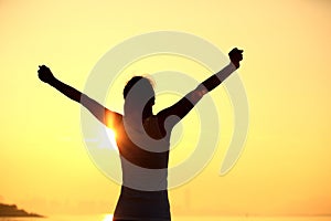 Strong confident woman open arms on beach