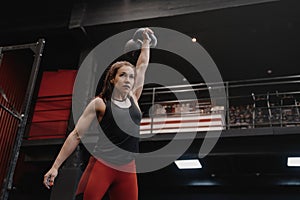 Strong crossfit woman exercising with a kettlebell at the gym. Female doing functional training