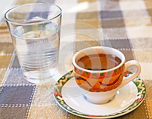 Strong Cypriot coffee with water in a glass