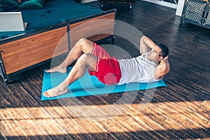 Strong dark-haired man in red shorts having a workout