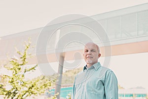 Strong, determined older man outside a modern company