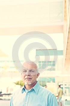 Strong, determined older man outside a modern company