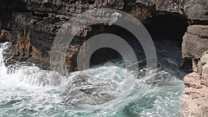 Strong extreme waves crash into grotto cliff cave, Boca do Inferno, Portugal