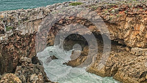 Strong extreme waves crash into grotto cliff cave, Boca do Inferno, Portugal