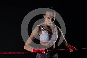 A strong fighter is holding a red line ring. Athletic woman focused before the fight.