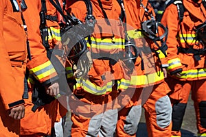 Strong Firefighters in fireproof uniform and stand in line to prepare for extinguishing fires. Team work concept