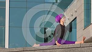 Strong flexible sports muslim young girl yogi woman doing workout exercises practice in city asana yoga pose of three