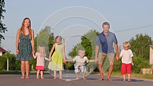 Strong friendly family holding hands jumping on the road.