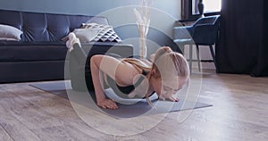 Strong girl doing intensive push-ups on yoga mat on knees