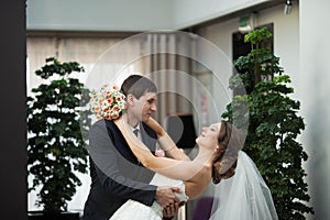 strong groom holds his bride