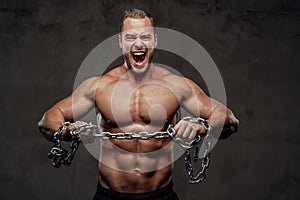 Strong guy with chains posing in special background