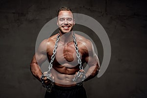 Strong guy with chains posing in special background