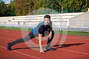 Strong guy doing stretching before jogging