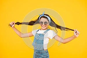 Strong hair. Cute kid fashion girl. Summer fashion concept. Girl long curly hair sunglasses tied head scarf. Fashion