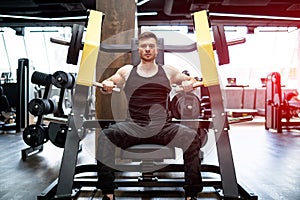 Strong handsome bodybuilder working in the gym. Muscular athletic man training hard.