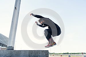 Strong and handsome healthy bearded man doing plyometric jump exercise in crossfit workout outdoors.