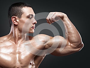 Strong and handsome young bodybuilder demonstrate his muscles an