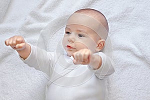 Strong healthy baby looking at fists