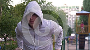 A strong, healthy man, doing pullups on the bars Park Sunrise workout, slow motion