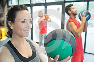 Strong healthy woman holding heavy medicine ball in gym workout