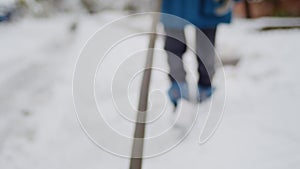 A strong helper boy, amidst a snowy storm, clears a difficult path, facing down the cold winter