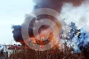Strong house fire, fire and black column of smoke. Blurred image