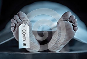 Strong image of feet with toe tag of a dead body coronavirus victim. COVID-19 deaths Health alert