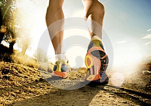 Chiudere in su con i piedi con le scarpe da corsa e forte atletico gambe di sport uomo jogging fitness training on off road pista design nel cartellone pubblicitario di stile nel tramonto paese di sfondo.