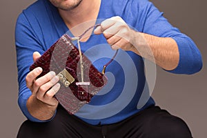 Strong male hands holding handbags