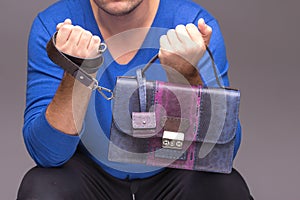 Strong male hands holding handbags