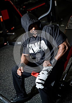 Strong male having rest after training. Handsome young bodybuilder in sportswear hard working.