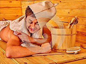 Strong male people in hat at sauna.