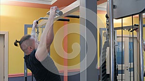 Strong man athlete doing pull ups chin ups in the gym