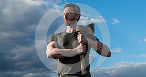 strong man with axe. woodcutter man hold ax. brutal man on sky background