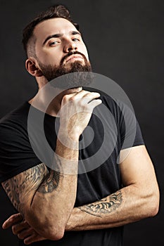 Strong man in black tight fitted shirt with a serious expression on his face.