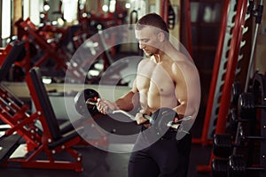 Strong man bodybuilder in a gym exercising with a barbell