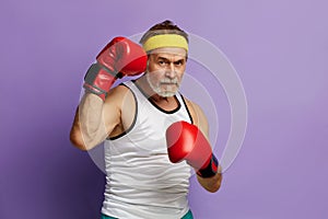 Strong Man Boxing In Gloves. Portrait of Senior Man Training