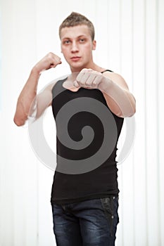 Strong man in boxing pose standing on white background